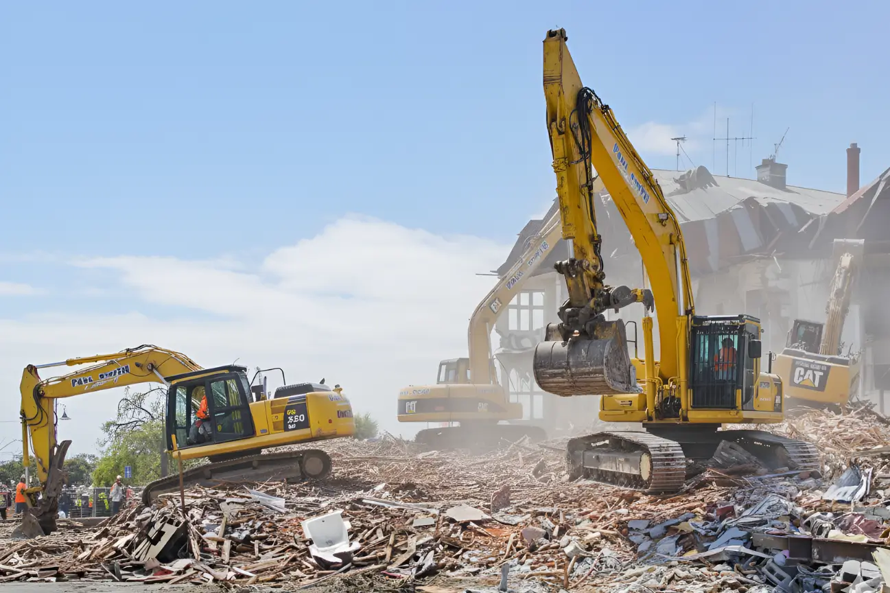 Multiple yellow excavators clearing a large debris site for RHL Build HB Earthworks.